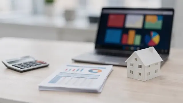 Bonität beim Immobilienkredit: Unterlagen, Taschenrechner und Hausmodell zur Kreditwürdigkeitsprüfung bei Banken